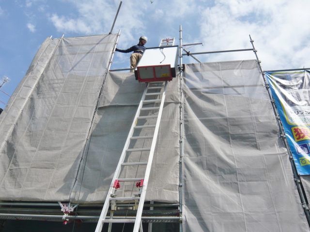 ２階建て住宅の屋根に太陽光パネルの設置工事を行っています。