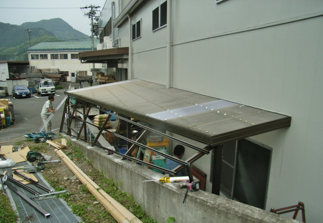 材料置き場のひさしの脇から雨が入ってしまうので、アルミ枠を組んでタキロンで塞ぐ工事を行っております。